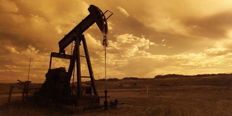 sepia picture of a solitary oil rig with a barren landscape in the background