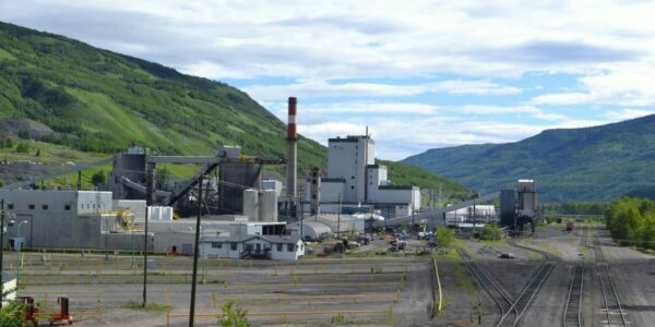CST Canada Coal's mine project in Greenview near Grande Cache featuring a smoke stack and buildings with green mountains in the background
