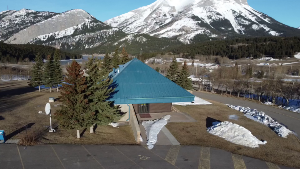an aerial shot of the PEAKS campus in Coleman Alberta featuring a view of the snow covered mountains in the background and the open area surrounding the campus