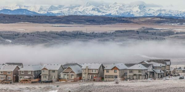 a beautiful shot of Cochrane Alberta with houses at the forefront and the Rocky Mountains in the background
