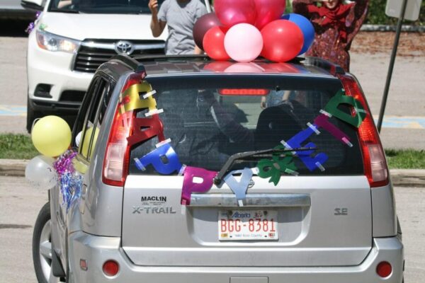 a car decorated with balloons and banners in celebration of eid al fitr in Calgary