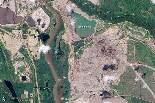 a satellite image showing just how close imperial oils tailings pond is to the athabasca river