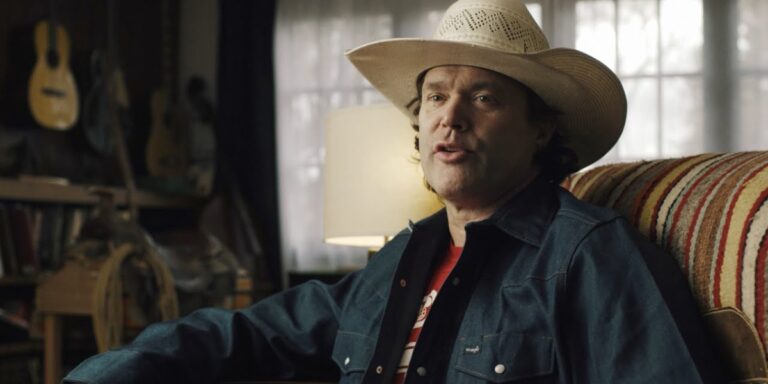 corb lund sitting on a coach speaking during an interview