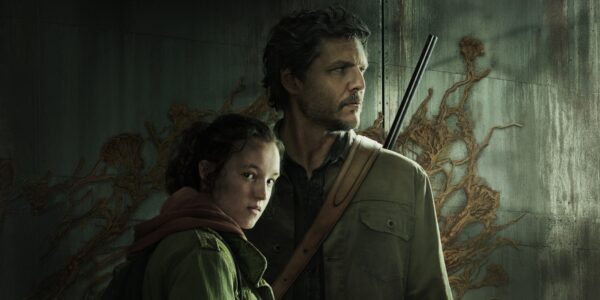 an image of ellie huddled next to joe who has a rifle slung over his back with fungus climbing the wall behind them