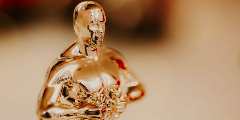 a photo of the top half of an Oscars trophy showing off its polished gold shine