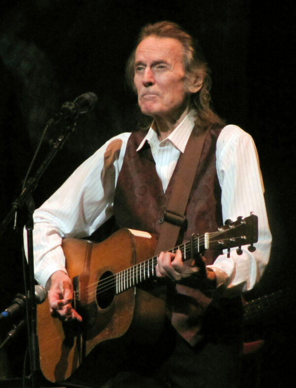 gordon lightfoot playing the guitar during a performance