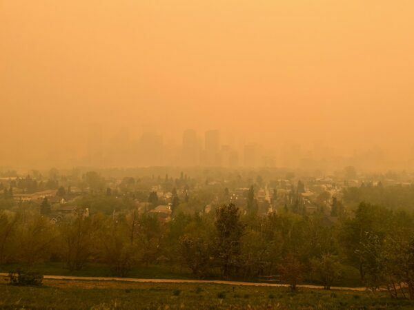the city of calgary blanketed in an orange smoke from nearby wildfires