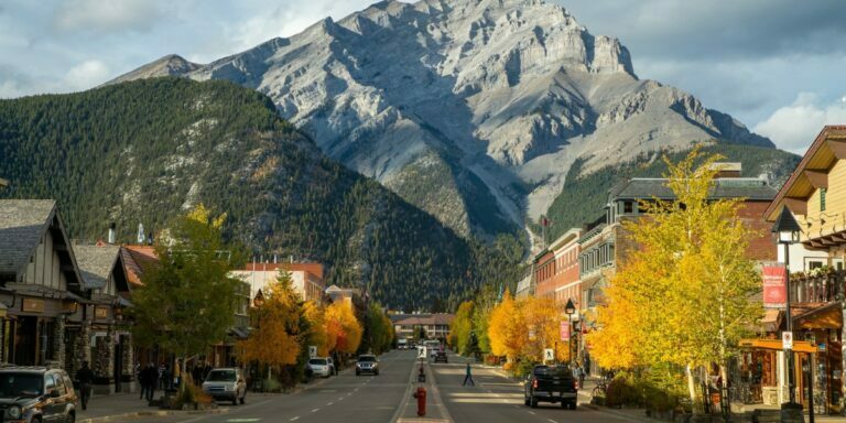 a beautiful photo of banff in what looks like fall with the mountain the background and buildings in the foreground