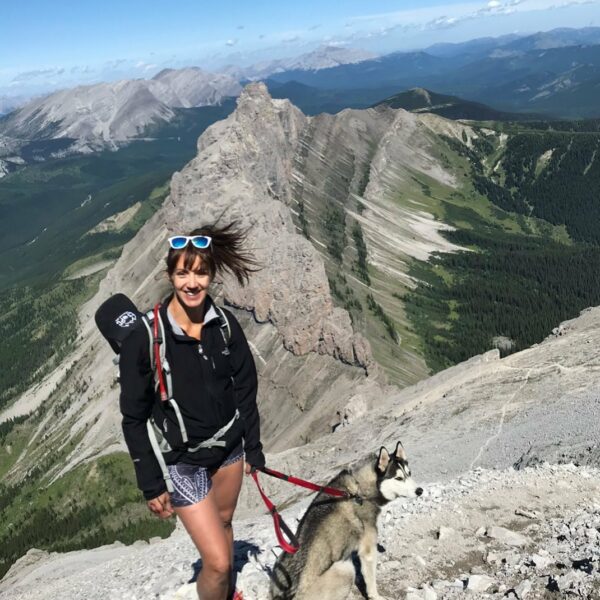 a photo of danielle radvak on a mountain with her husky 