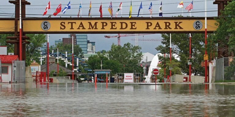 a photo of the stampede park entrance completely flooded with water covering the entire stretch of road