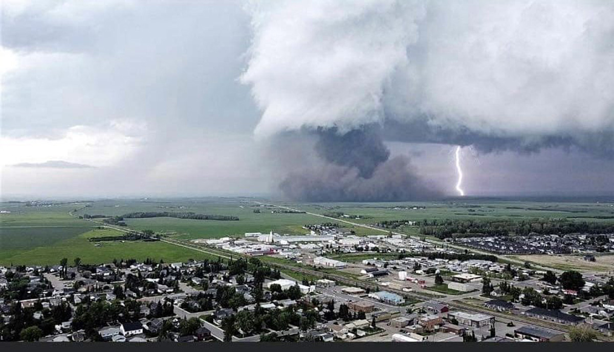 Aerial view over Carstairs, Alberta showing showing approaching tornado on July 1, 2023 