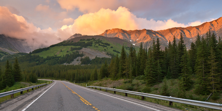 photo of highway through beautiful mountain scenery.