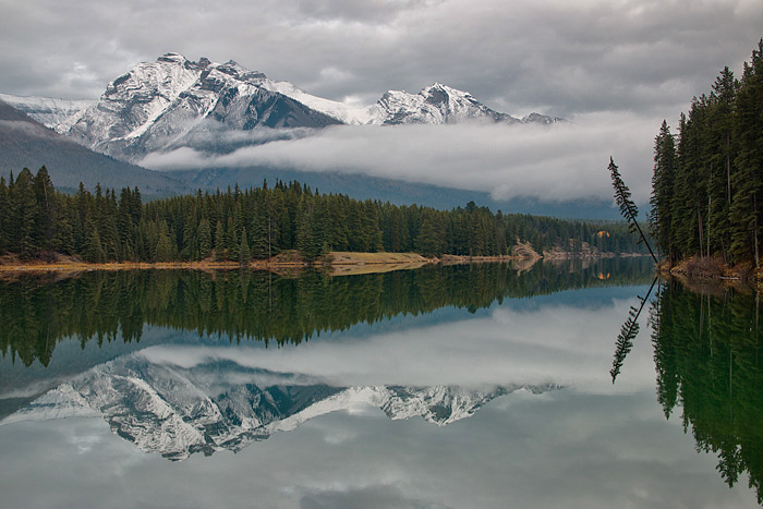 Mountains reflected in perfectly calm lake in Banff National Park.