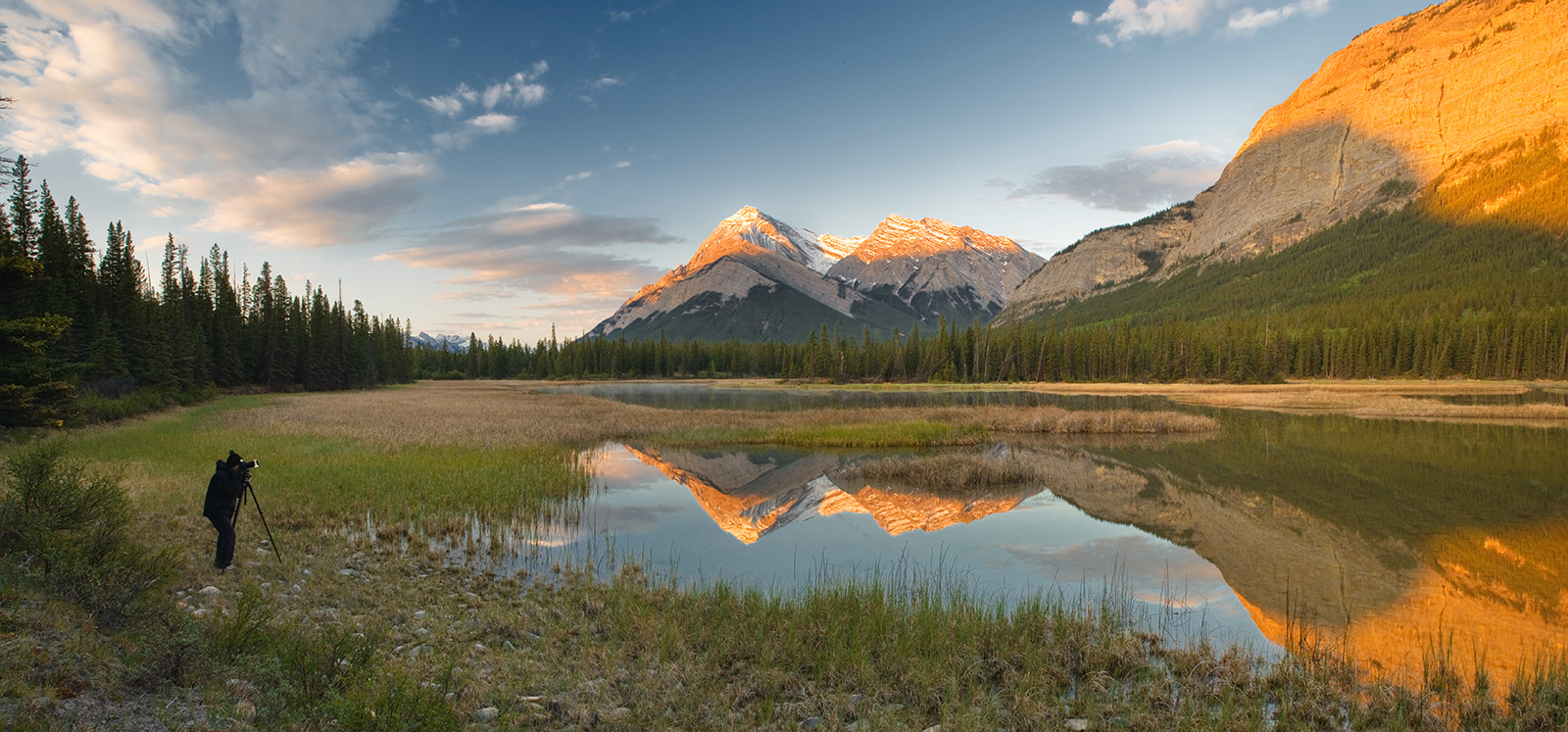 Photographer photographing a mountain lake at sunrise in the Canadian Rockies