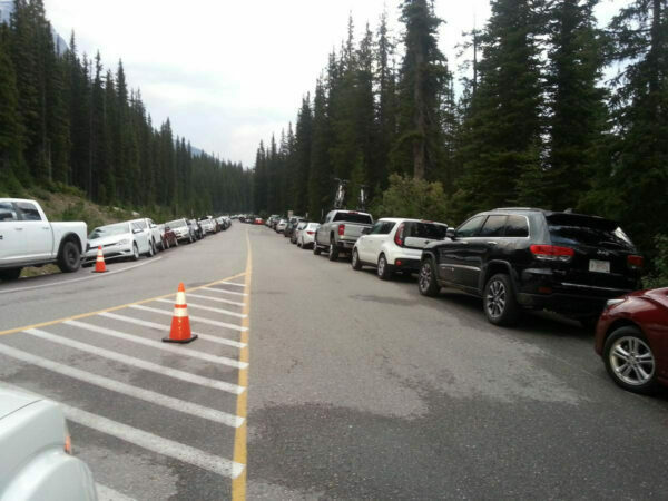 Overflowing traffic parked alongside the road to Moraine Lake