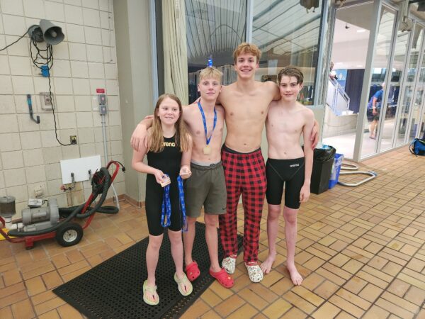 a photo of four swimmers that received medals from the Bow Valley Riptides swim club from Canmore
