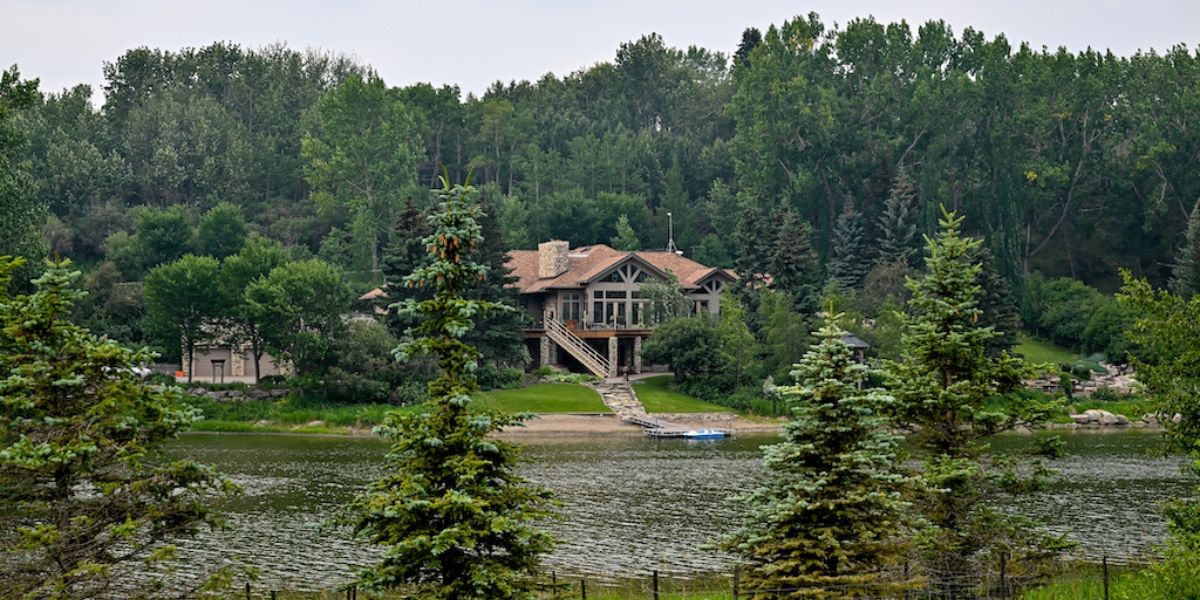 a gorgeous picture of what looks like a residential home on soderglen ranch completely surrounded by tall green trees and access to the creek right in front of the house