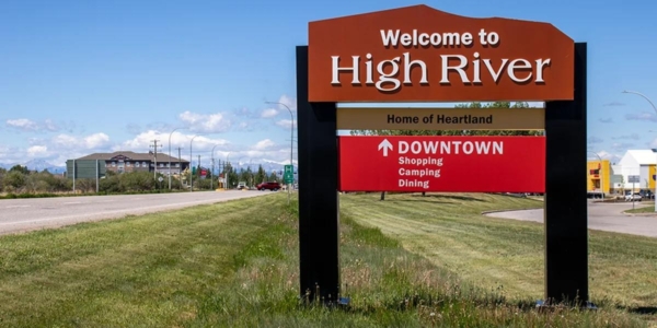 a red sign that reads welcome to high river with direction to downtown
