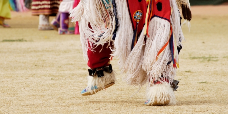 Close up of Indigenous dancer wearing beaded regalia at a pow-wow