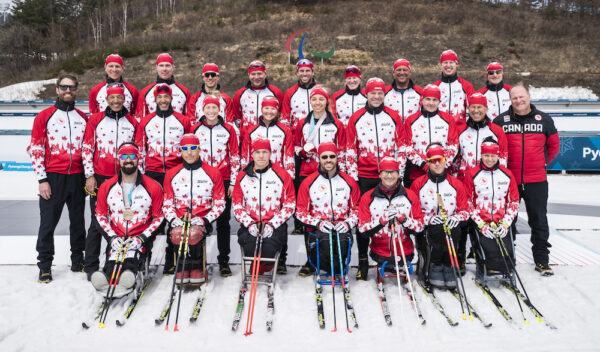 canadas para nordic team posing for a photo with their skis and red and white uniform