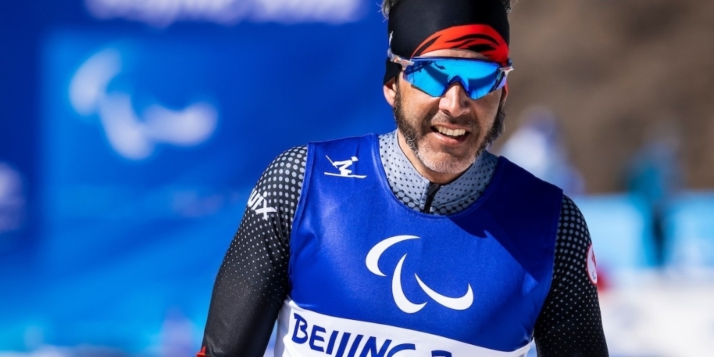 brian mckeever at the 2022 beijing winter paralympic games wearing a blue ski shirt with blue goggles