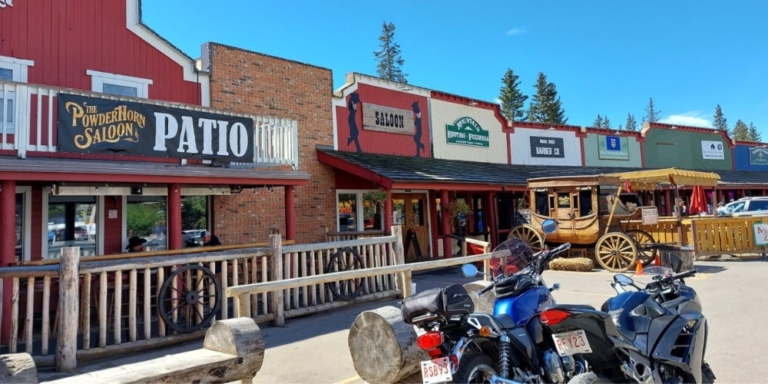 a street in bragg creek featuring a patio and motorcycles parked outside
