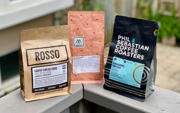 Photo of three packages of coffee beans from three different Calgary coffee roasters.