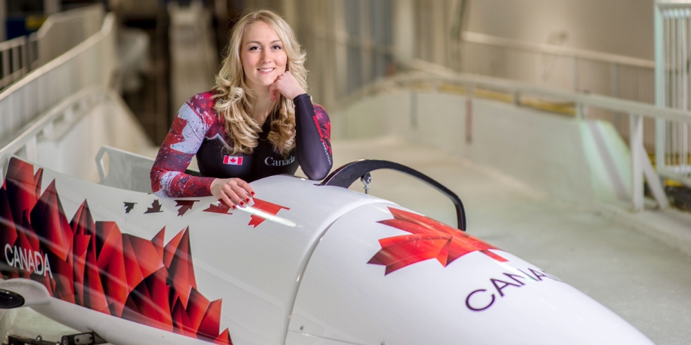 woman posing beside a bobsled