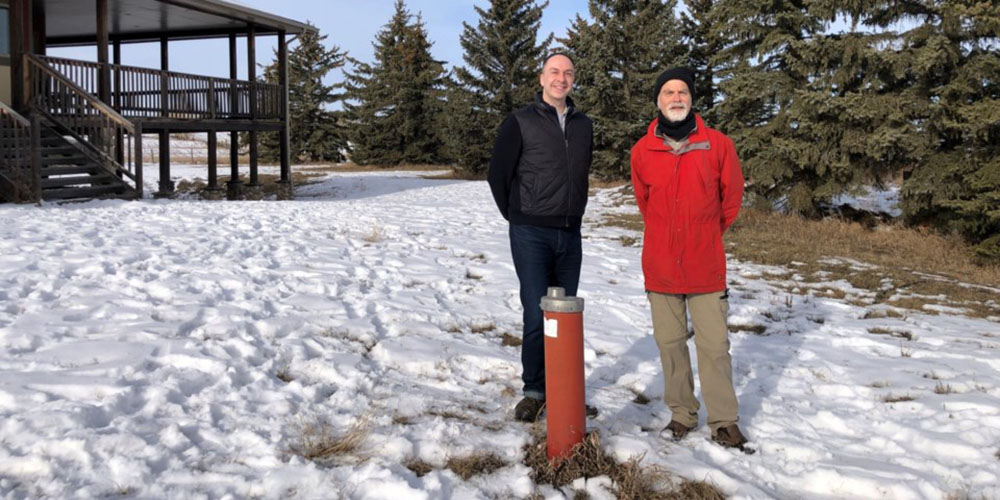 Dr. Aaron Goodarzi (left) and Henk de Haan next to a groundwater well on de Haan's property near Okotoks  Cochrane Eagle