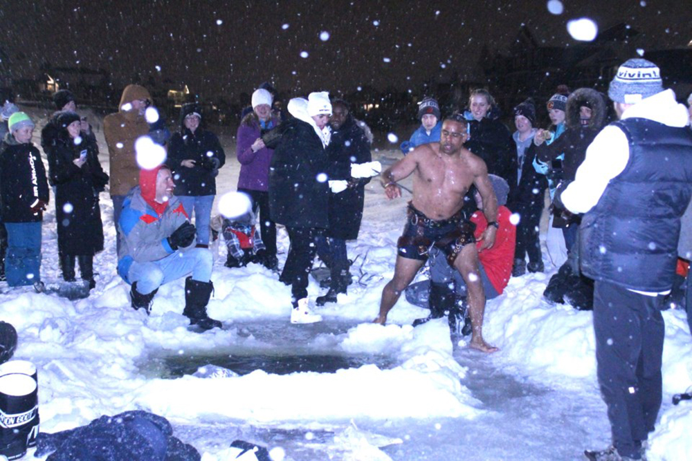 Belibi (shirtless) after performing three polar bear plunges in Airdrie's Bayside canal