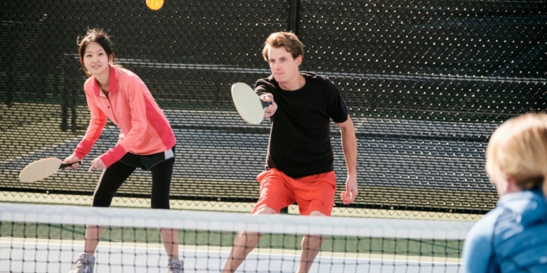 Young people playing pickleball